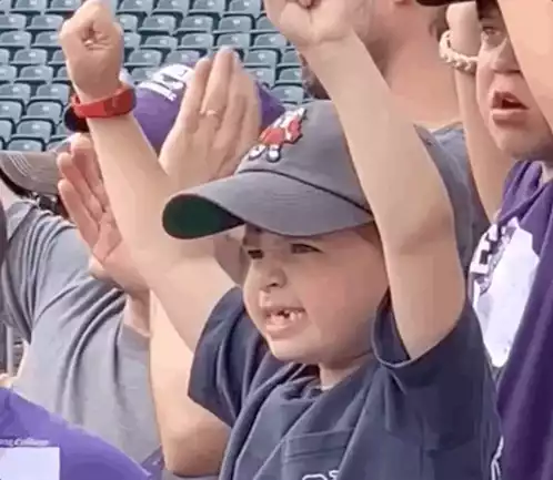 Excited Boy Cheers with Hands Up
